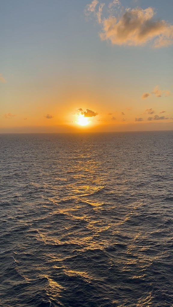 Sunset over the open ocean with golden reflections