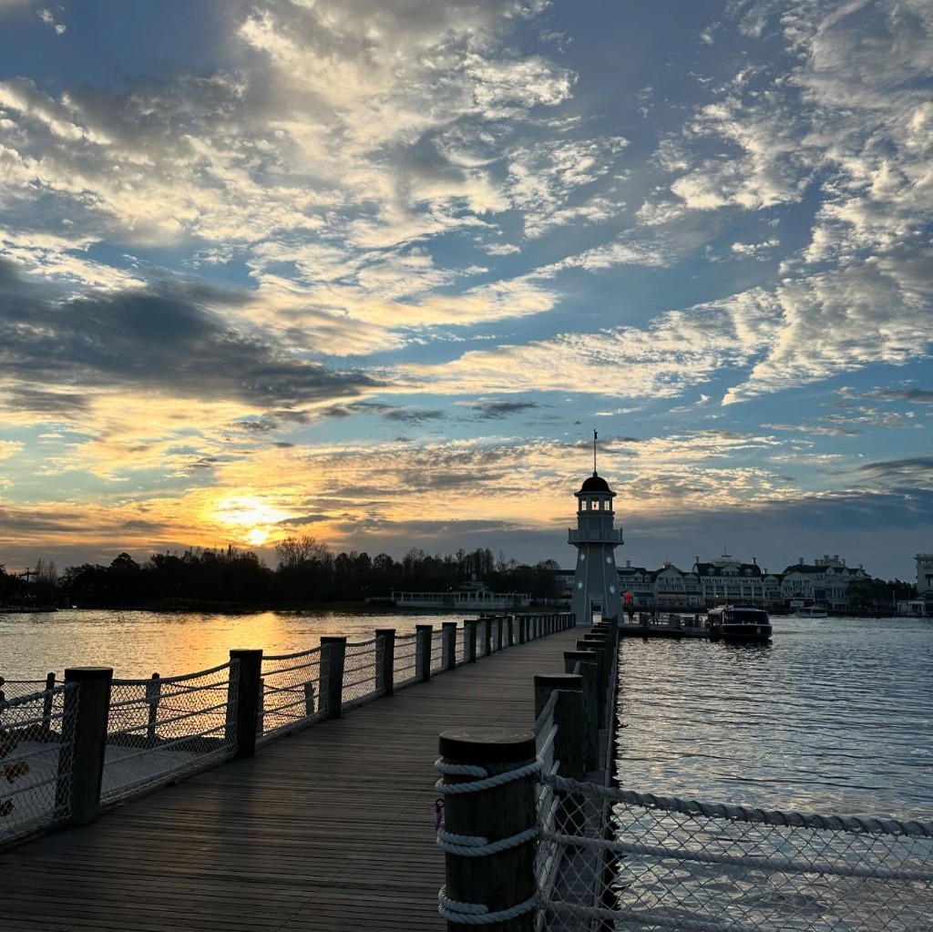 Boardwalk and lighthouse at sunset over the water